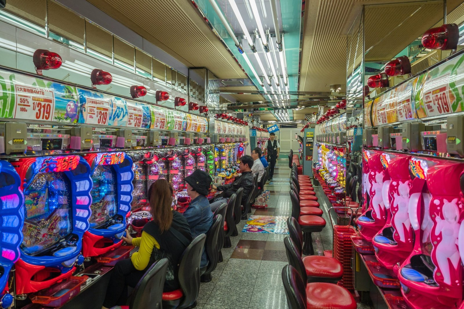 people sitting on red plastic chairs inside building